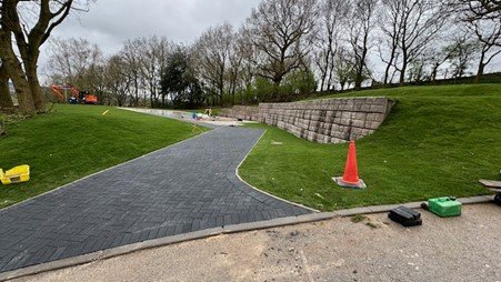 Retainer-Rock walling holding a grass bank beside a new block-paved access road