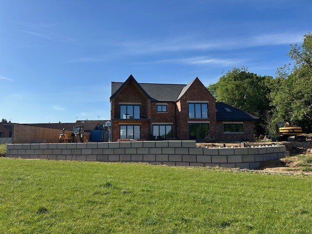 Low interlocking block retaining wall along the boundary of a new detached house