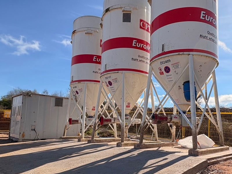 Row of cement silos standing on precast concrete foundation base slabs