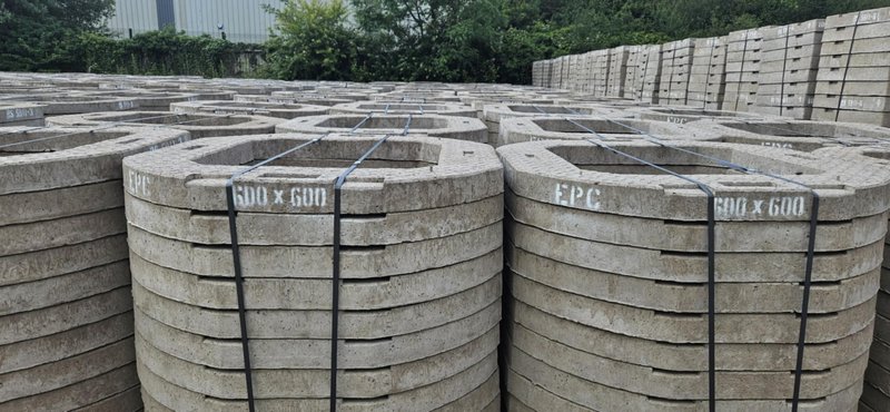 Rows of circular adjusting units marked 600 x 600 stacked in the yard