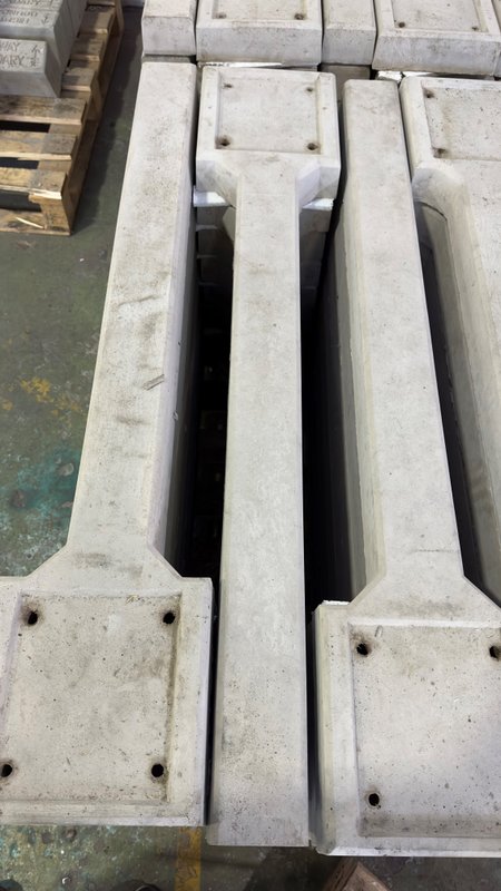 Precast concrete cable indicator posts stacked on timber pallets in a yard