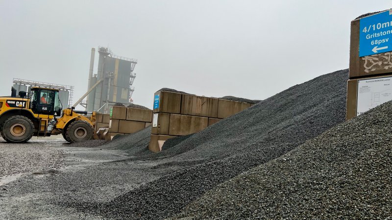 Loading shovel working aggregate stockpiles held in interlocking block storage bays