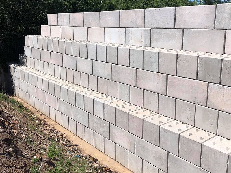 Stepped interlocking block retaining wall built into a sloping bank