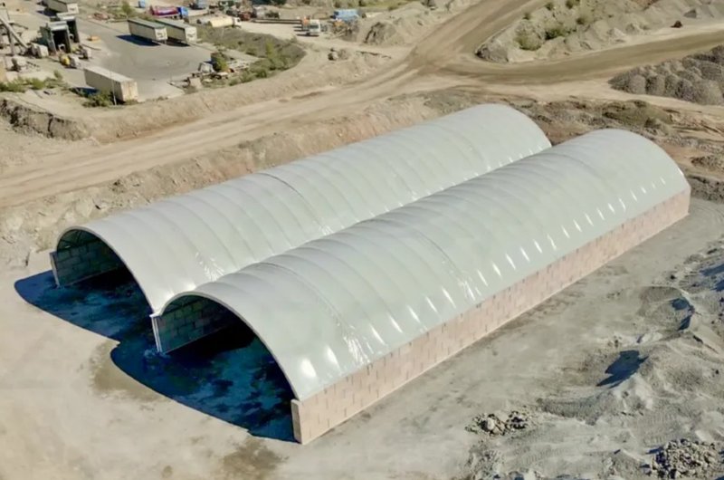 Aerial view of twin fabric shelters on block bay walls at a quarry