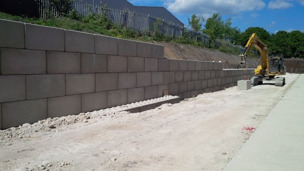 Long Legato block retaining wall with an excavator working behind it