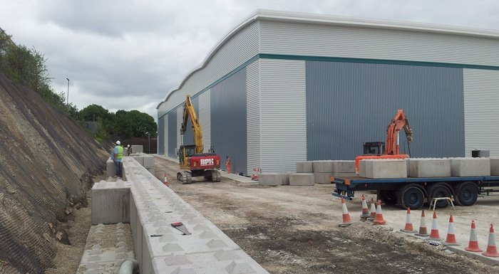 Lorry and excavator delivering Legato blocks alongside a new industrial building