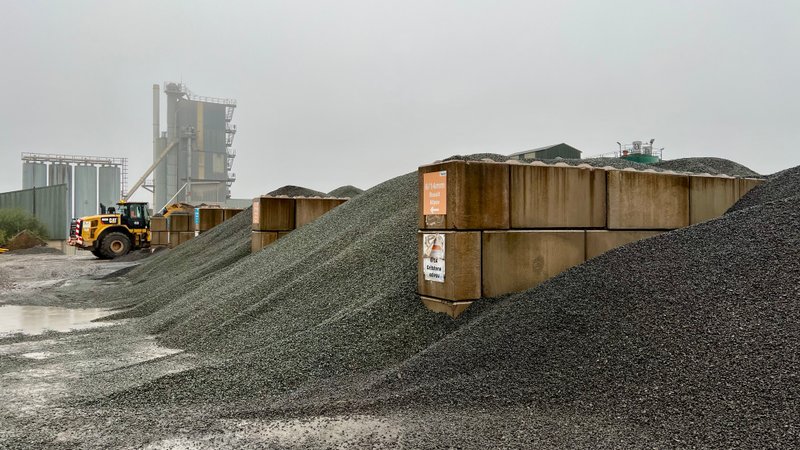 Aggregate stockpiles between block storage bays with a loading shovel at a plant