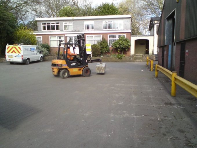 Forklift carrying a Duo block across a yard between industrial buildings