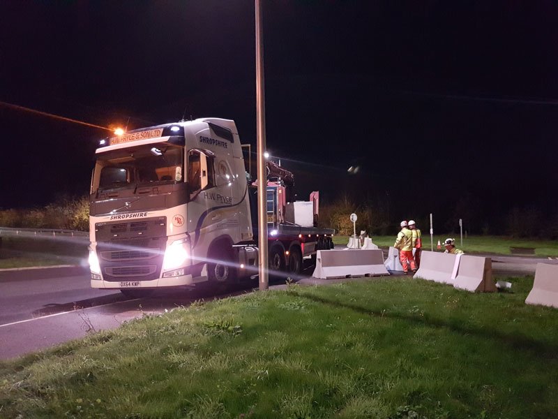 Night delivery of Jersey barriers being unloaded for a road closure