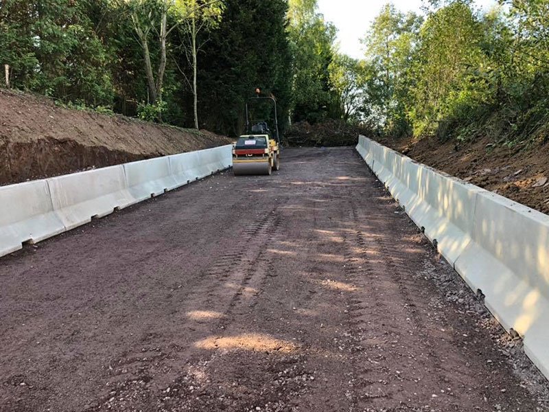 Jersey barriers lining both sides of a haul road through a development site