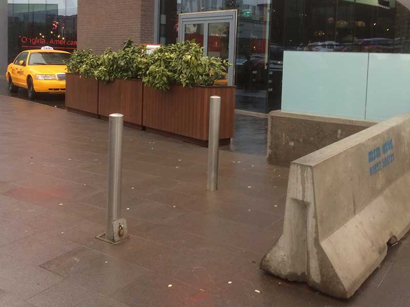 Jersey barrier and stainless bollards protecting a paved town centre frontage