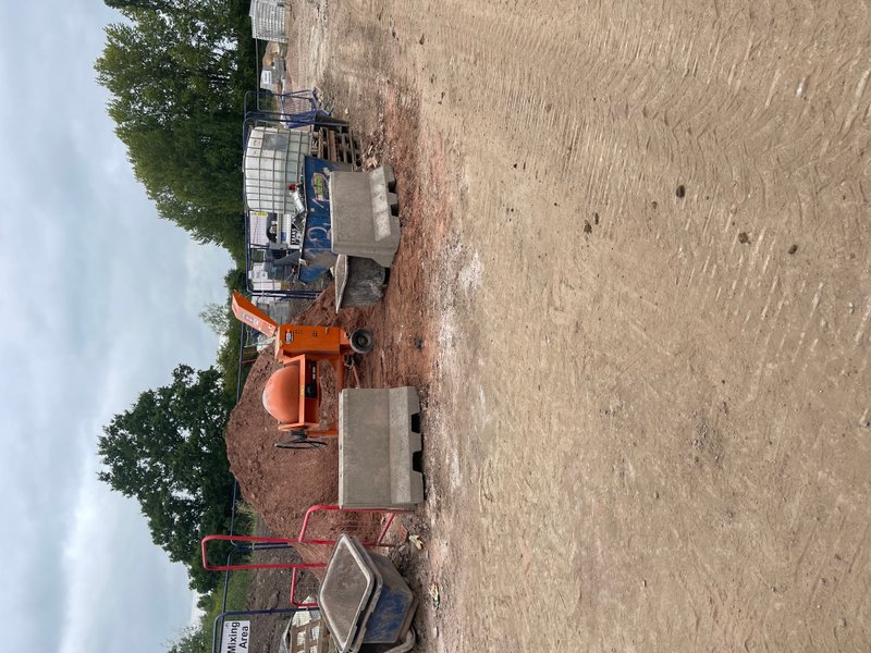 Jersey-Lite barrier beside site plant on a bare earth construction site