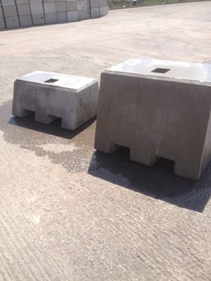 Pair of kentledge ballast blocks with lifting pockets on a concrete yard