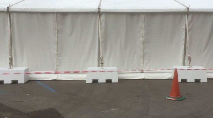 Ballast blocks weighting the edge of a large white event marquee