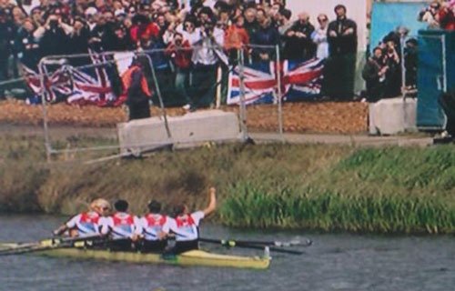 Ballast blocks anchoring spectator barriers at a flag-waving rowing event