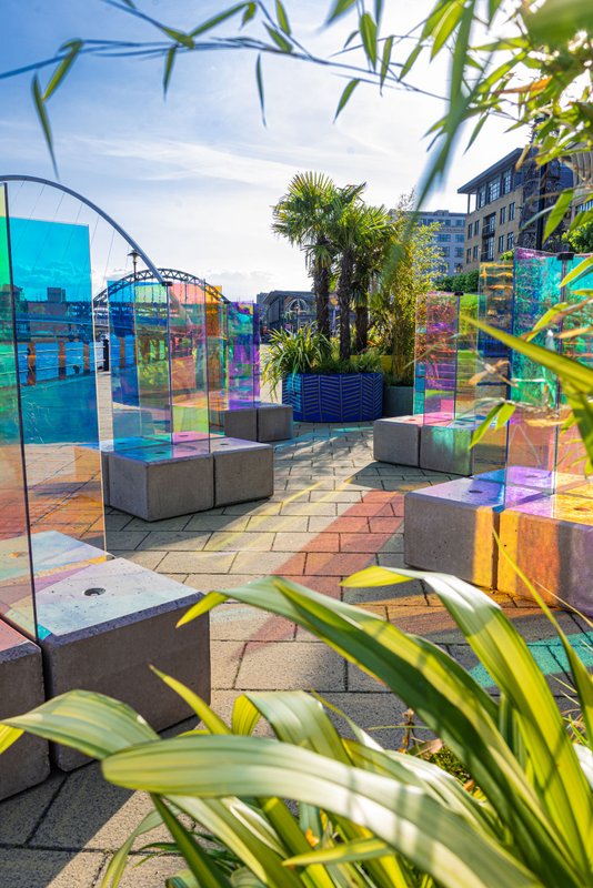 Coloured glass art panels and concrete block seats in a planted quayside terrace
