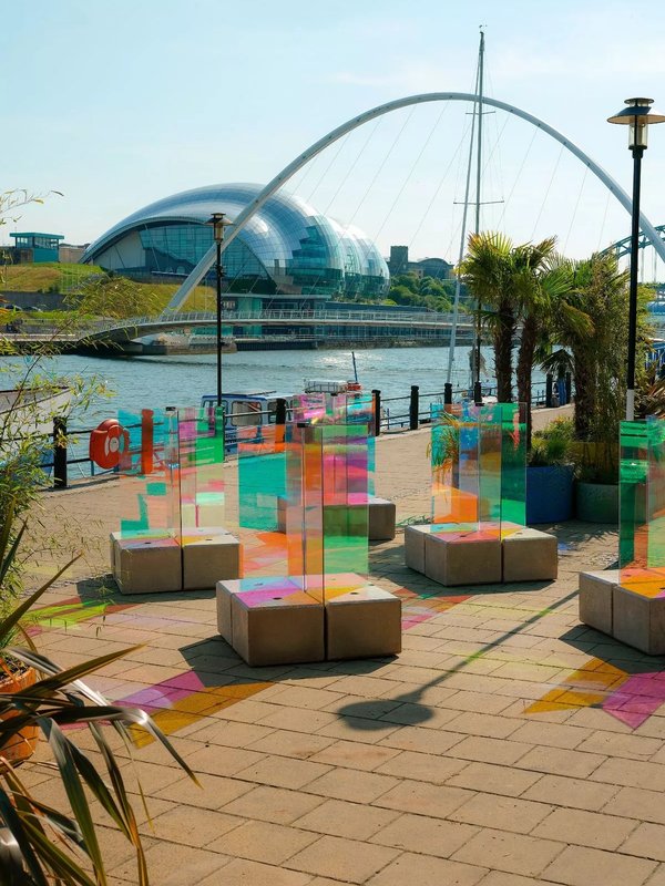 Coloured glass panels and concrete block seats in a quayside art installation
