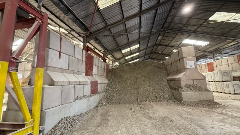 Interlocking block walls forming an indoor storage bay holding a sand stockpile