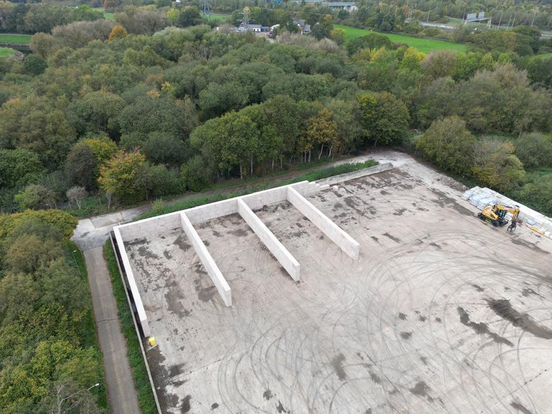 Aerial view of precast dividing walls forming bays on a new concrete pad