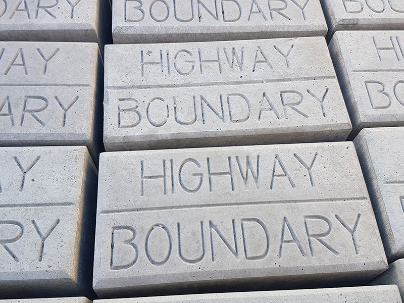 Close-up of stacked marker blocks embossed with Highway Boundary lettering