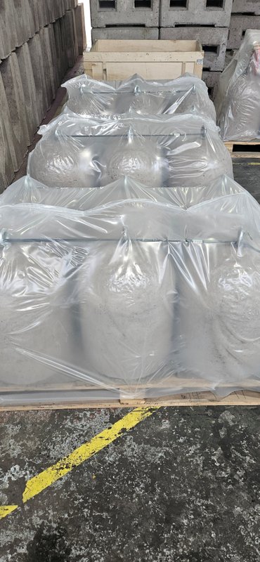 Shrink-wrapped concrete bollards stacked on pallets ready for delivery