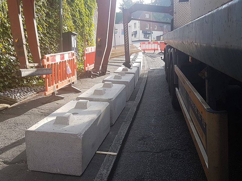 Concrete ballast block kentledging temporary barriers along a narrow city street