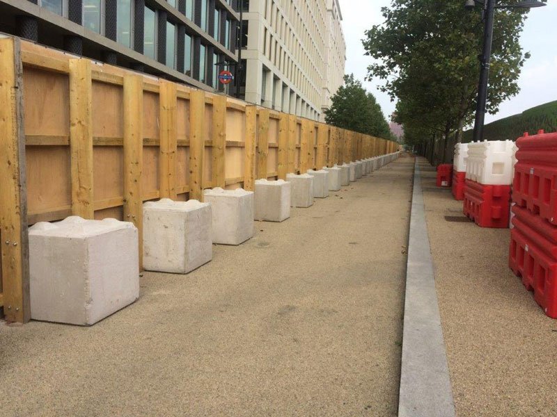 Legato blocks ballasting a timber site hoarding along a city footpath