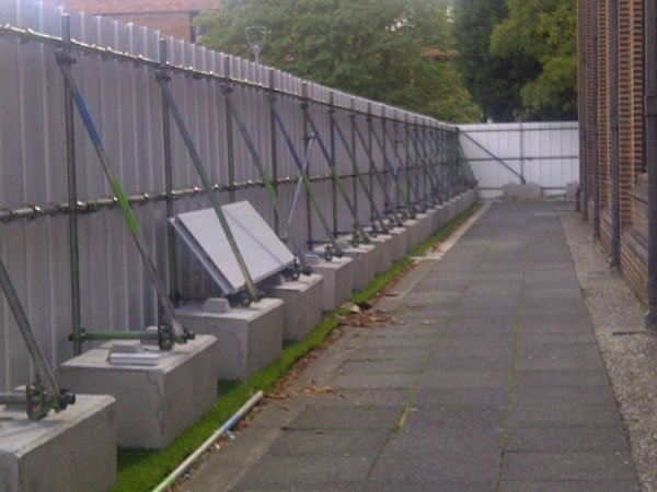 Braced site hoarding supported on a long line of kentledge blocks