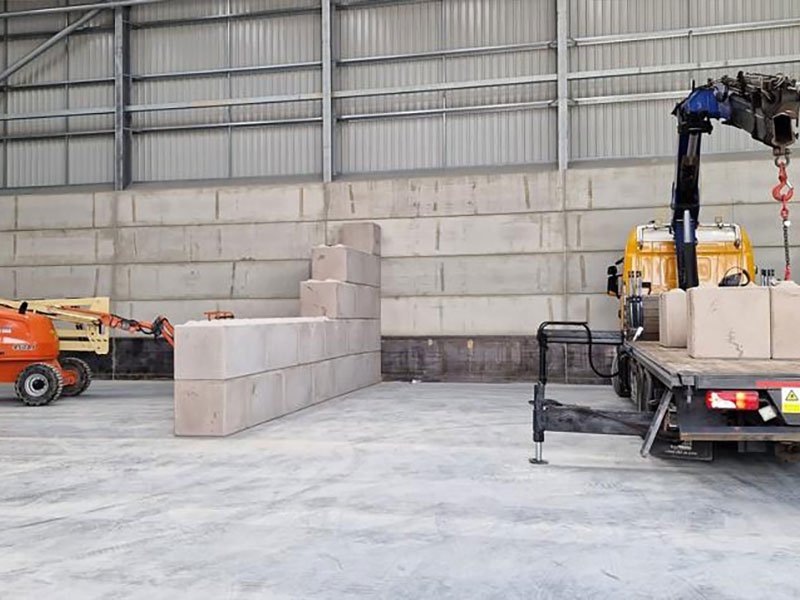 Lorry-mounted crane offloading Legato blocks inside a warehouse