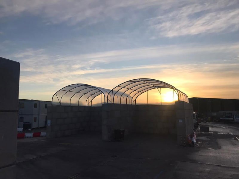 Legato block bay walls and a fabric canopy silhouetted against a sunset