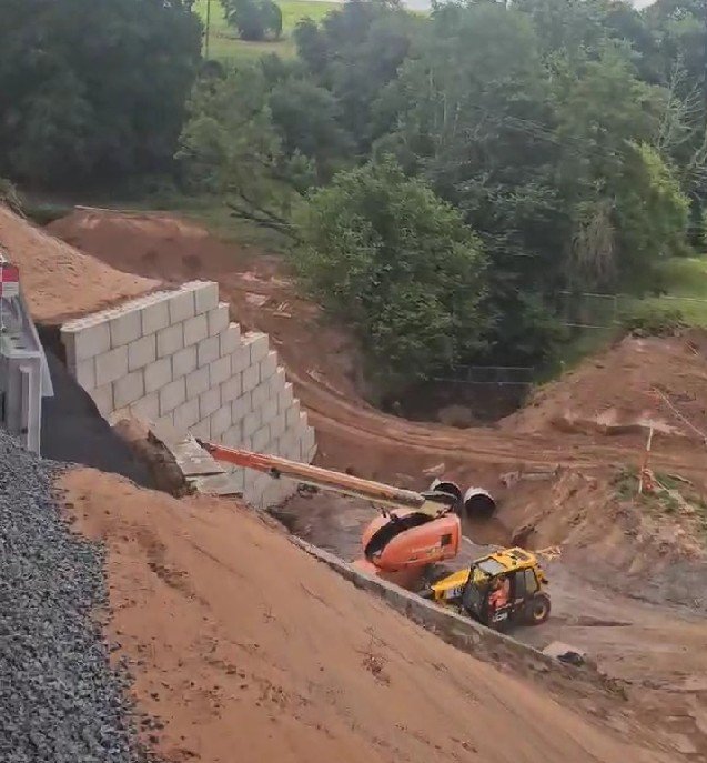 Interlocking block wall stabilising a landslipped embankment above working plant