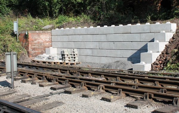 Stepped interlocking block wall forming a trackside refuge beside railway lines