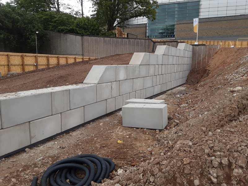 Stepped Legato block retaining wall forming a ramp beside a commercial building