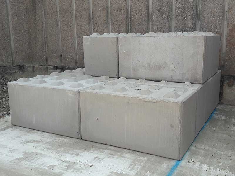 First courses of Legato interlocking blocks stacked against a concrete panel wall