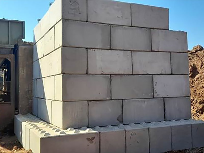 Stepped Legato interlocking block wall stacked several courses high against blue sky