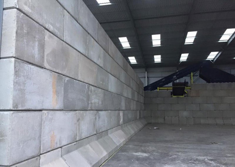 Long interlocking block dividing wall inside an empty industrial shed