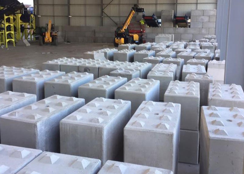 Rows of Legato interlocking blocks laid out on a shed floor before wall construction