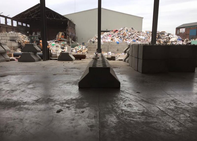 Interlocking block push walls forming bays in a waste transfer shed