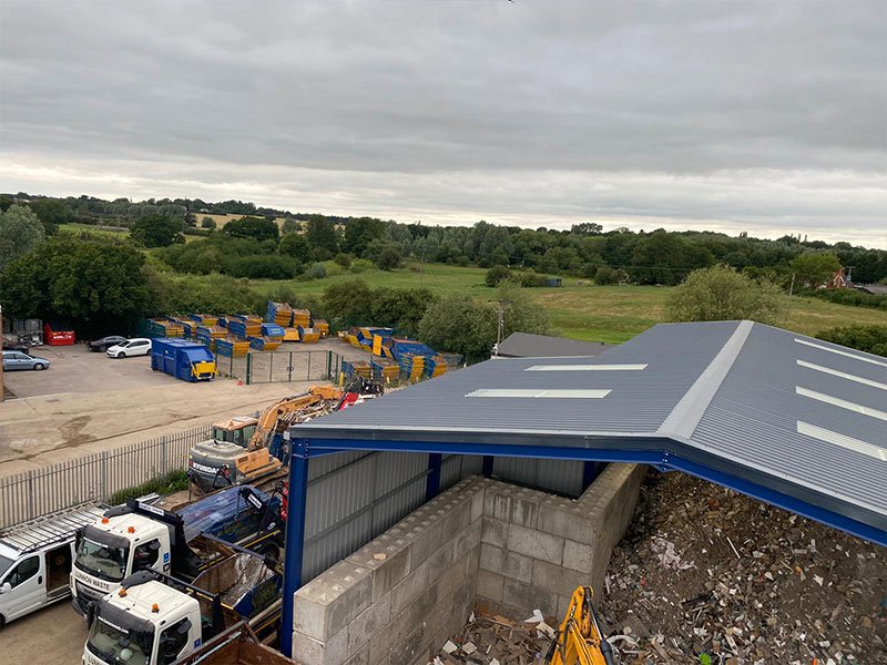 Legato block bays beside an open-sided shed at a scrap metal yard