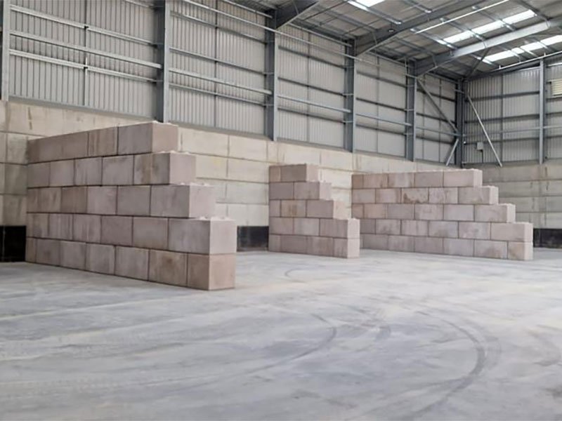 Legato interlocking blocks stacked into stepped bay walls inside a warehouse
