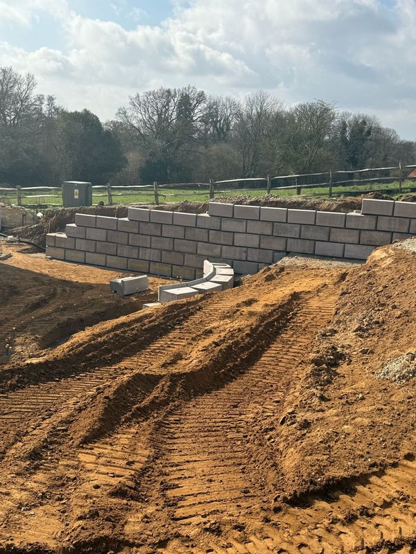 Smooth-faced walling blocks retaining freshly excavated ground on a rural site