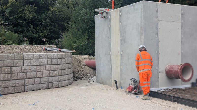 Curved Retainer-Rock cobblestone walling beside a concrete tank at a water treatment works