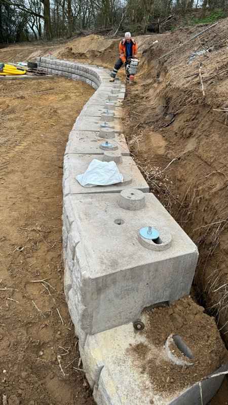 Retainer-Rock walling curving through excavated ground during installation
