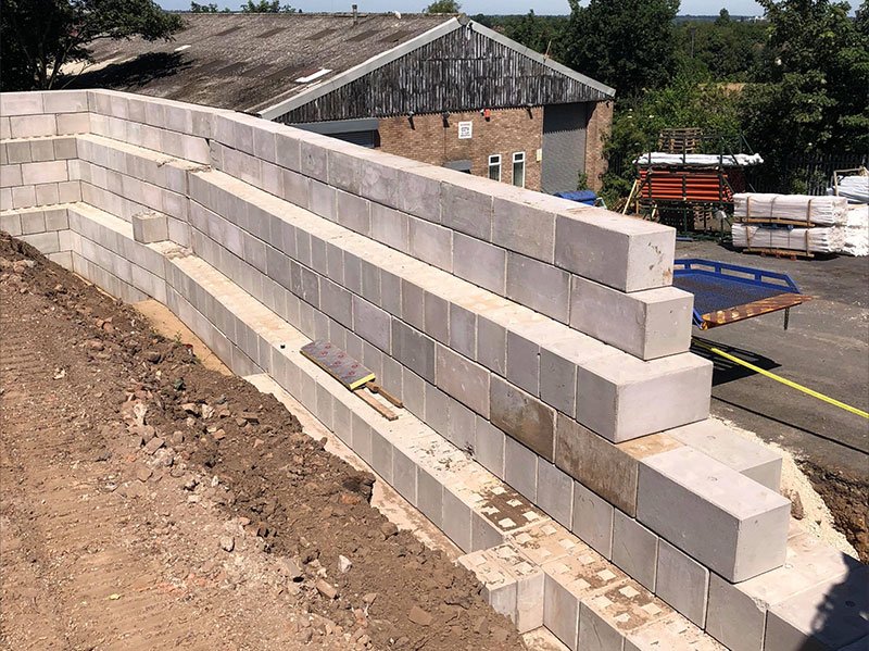 Stepped Legato block retaining wall terracing a bank beside a building