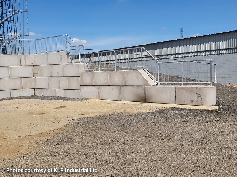 Legato retaining wall with a steel access staircase beside an industrial unit
