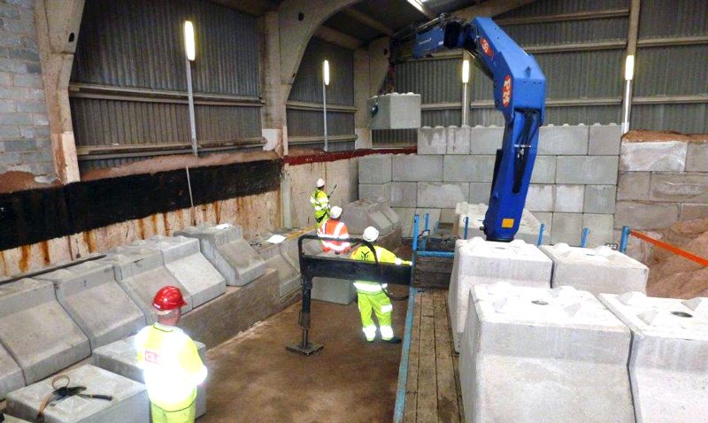 Installers craning Legato blocks into place along a salt barn wall