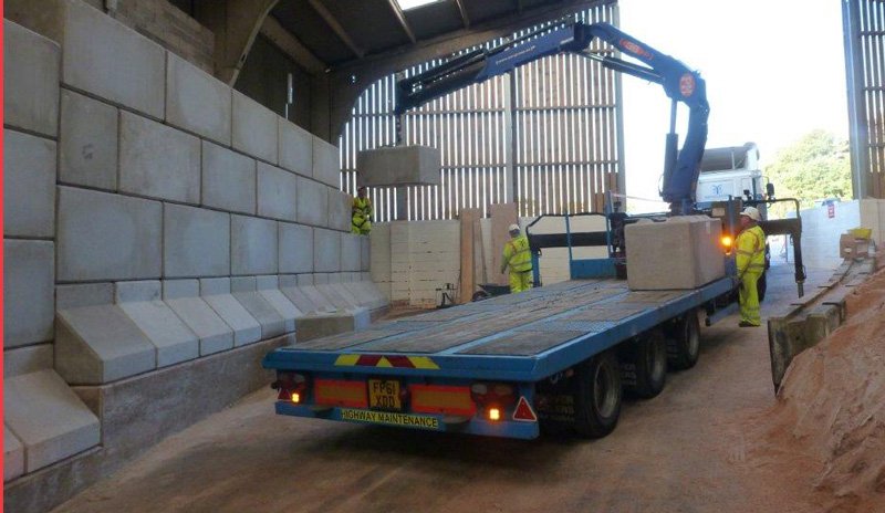 Flatbed lorry with crane delivering Legato blocks into a salt barn