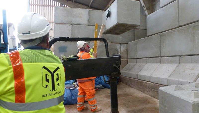 Installation crew with lifting equipment building a Legato block wall