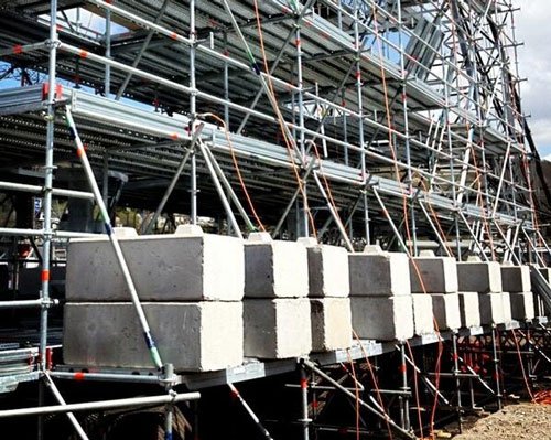 Duo kentledge blocks ballasting a scaffold run along a building