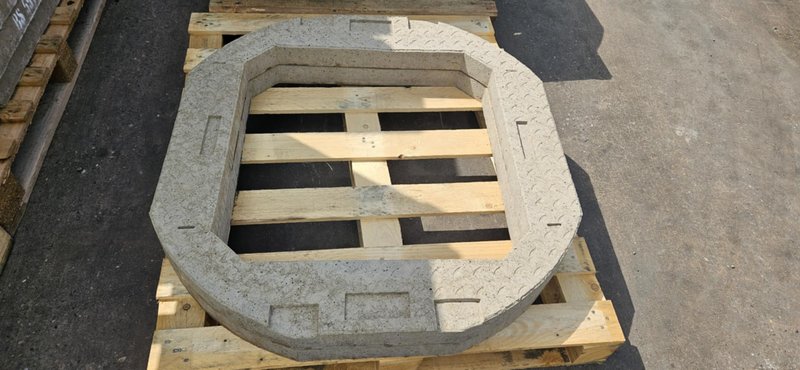 Single precast concrete seating ring resting on a timber pallet in a yard
